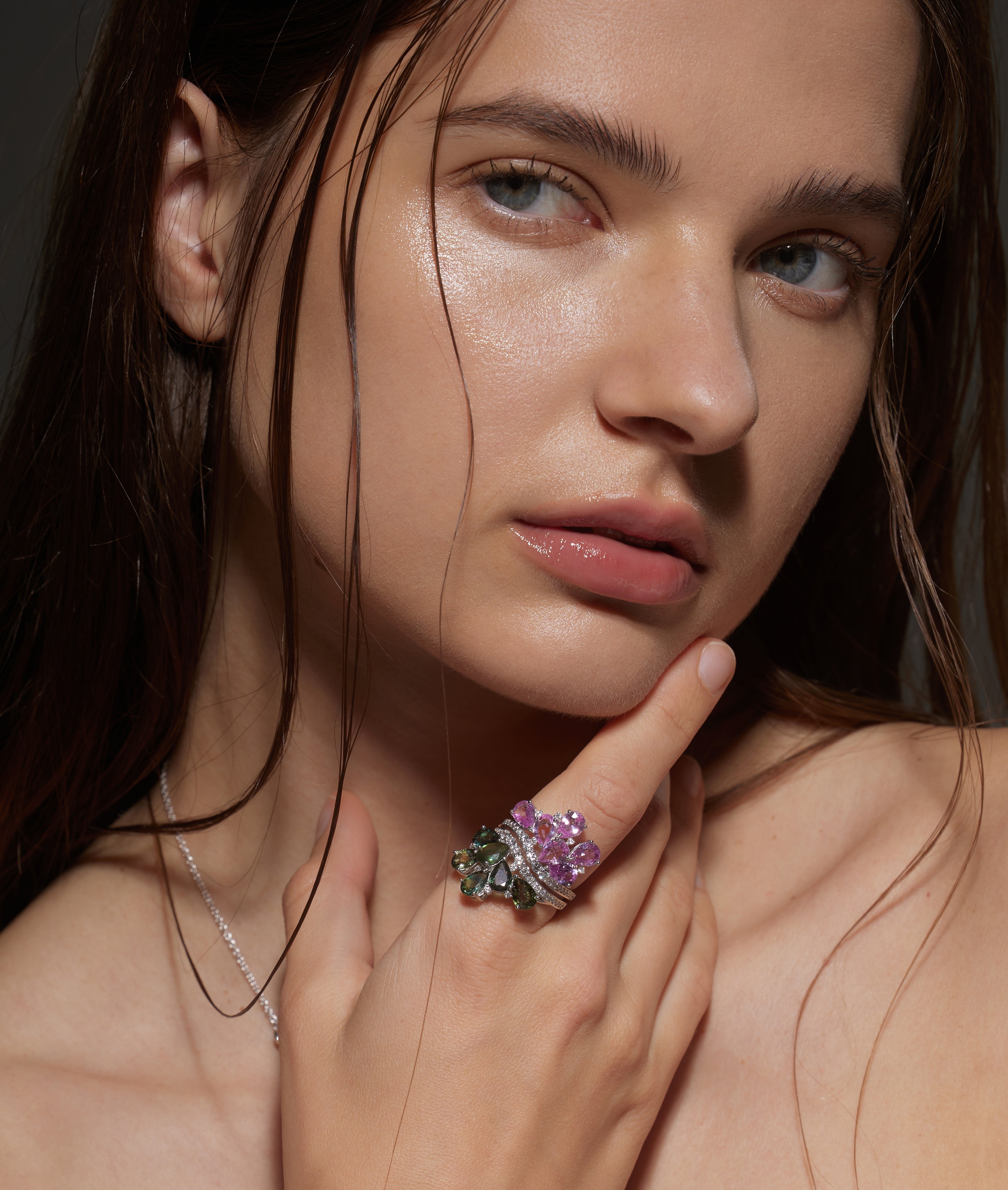 Model wears White Gold pink and green Twin Blossom Ring as she touches her face