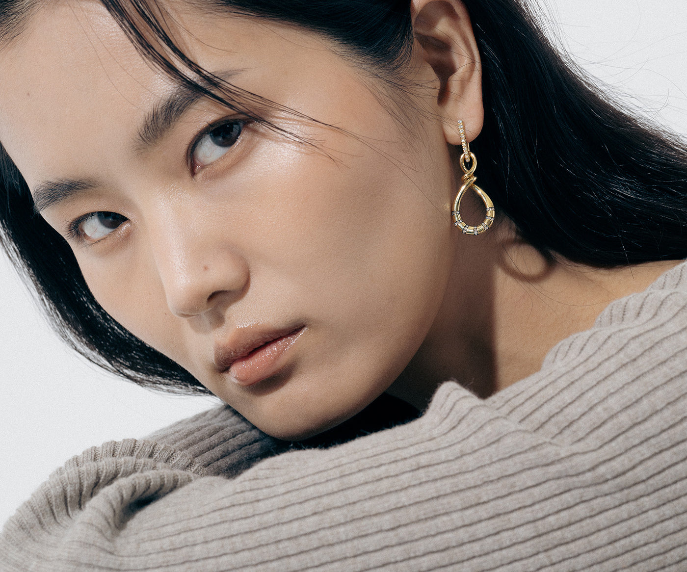 Yellow Gold Earrings in an uneven figure 8, with Rhodium Plated notches and Diamonds - Model shot